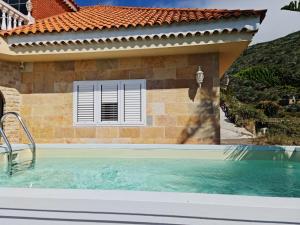 - une piscine en face d'une maison avec une fenêtre dans l'établissement Holiday Home Hemi, à Valsequillo de Gran Canaria