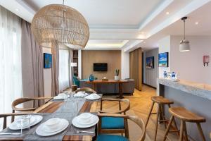 a dining room and living room with a table and chairs at Ulwazi Place Hotel by Trianum in Nairobi