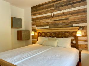 1 dormitorio con 1 cama y pared de madera en Garden Apartments Bled, en Bled
