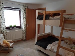 una camera con due letti a castello e una finestra di Ferienwohnung An der kleinen Schreinerei a Hallschlag