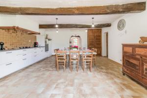 cocina y comedor con mesa y sillas en Le Relais de Soubeille en Boulogne-sur-Gesse