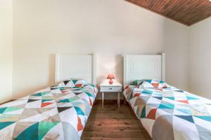 dos camas sentadas una al lado de la otra en un dormitorio en Le Relais de Soubeille, en Boulogne-sur-Gesse