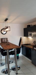 cocina con mesa de madera y sillas negras en Arreau appartement 4 personnes, en Arreau