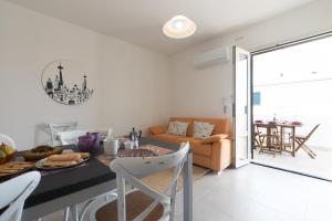 オロゼーイにあるCasa Lory - Appartamento con 2 camere in centro abitatoのテーブルと椅子のあるキッチンとリビングルーム +18枚の写真