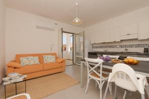 オロゼーイにあるCasa Lory - Appartamento con 2 camere in centro abitatoのソファとテーブルのあるリビングルームとキッチン