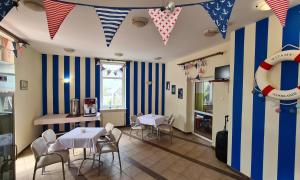 a dining room with blue and white striped walls at Meduza Natura Tour in Świnoujście