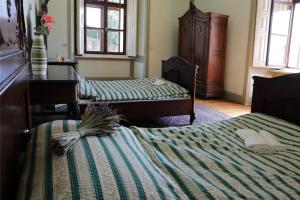 a bedroom with two beds and a table and windows at Zelenohorská pošta in Nepomuk