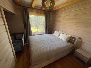 Habitación pequeña con cama y ventana en Dore en Lielvārde