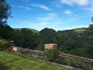 uma vista para as colinas a partir de um quintal em The George Borrow Hotel em Ponterwyd