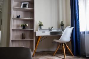 a desk and a white chair in a room at Il Paradiso di Malasits in Győr