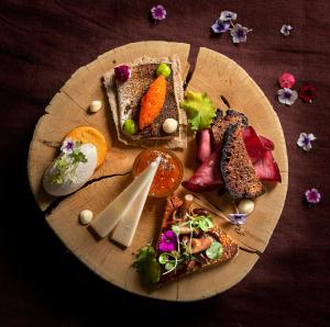 a wooden plate with different types of food on it at Lapland Hotels Saaga in Ylläsjärvi +78 photos