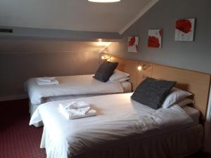 Habitación de hotel con 2 camas y toallas. en The George Borrow Hotel en Ponterwyd