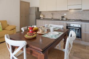 オロゼーイにあるCasa Antu - Appartamento con 2 camere in centro abitatoのキッチン(木製テーブル、白い椅子付) +24枚の写真