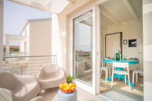 een kamer met een balkon met een tafel en stoelen bij MERMAID'S HOUSE in Isola Rossa