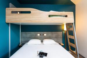 1 dormitorio con litera y escalera en ibis budget Porte D'Orleans, en París