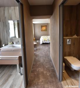 een badkamer met een wastafel en een bed in een kamer bij Logis Hôtel Beau Site in Loubaresse