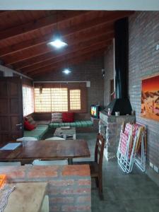 a living room with a table and a fireplace at Cabaña El Mirador de Bialet Masse in Villa Parque Siquiman