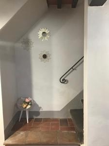 uma escada com uma cadeira e um espelho na parede em La casina in Via Fiorita em Montepulciano
