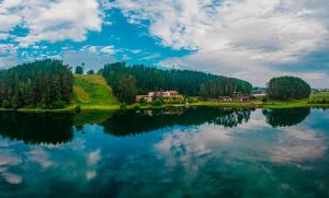 - une vue sur un lac avec des maisons et des arbres dans l'établissement Svečių namai ALDAIVITA, à Ignalina