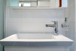 lavabo blanco en el baño con espejo en Europe Hotel en Argostoli