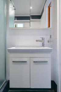 a white bathroom with a sink and a mirror at Europe Hotel in Argostoli