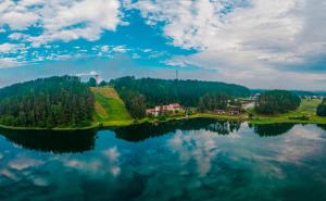 - une vue sur une grande étendue d'eau avec des arbres dans l'établissement Svečių namai ALDAIVITA, à Ignalina