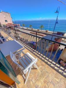 a chair sitting on a balcony overlooking the ocean at Casa La Marinella in Porto Santo Stefano