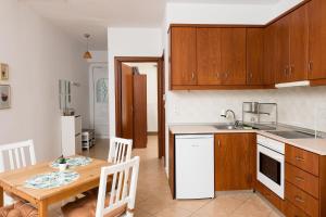 a kitchen and dining room with a wooden table and chairs at Aggelos Apartment in Limenas