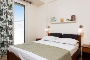 a bedroom with a bed and a large window at Aggelos Apartment in Limenas
