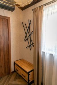um quarto com uma janela e um banco de madeira ao lado de uma cortina em Hotel Hunters House em Ezerets