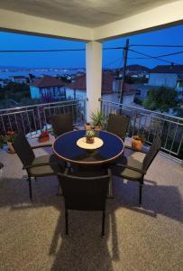 a patio with a table and chairs on a balcony at Apartman Sara in Preko