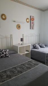 1 dormitorio con 2 camas, escritorio y 2 espejos en Hostal Diaz, en Madrid