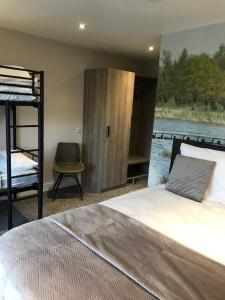 een slaapkamer met een bed en een stapelbed en een stoel bij Boutique Hotel en B&B De Zwammenberg in De Moer