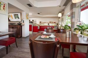 a dining room and kitchen with a table and chairs at Hotel Touristik in Neuenburg am Rhein +34 photos