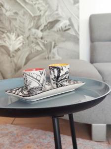 duas chávenas de chá sentadas num prato numa mesa em TERLA Bel Appartement 3 Pieces Clim & Parking em Saint-Pierre