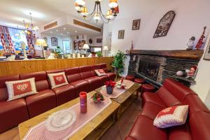 a living room with red couches and a fireplace at Hotel Restaurant La Source in La Foux