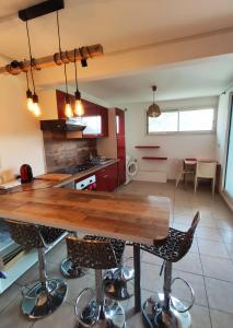 uma cozinha com uma mesa de madeira e cadeiras em TERLA Bel Appartement 3 Pieces Clim & Parking em Saint-Pierre