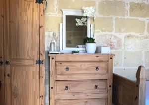 un comò in legno con uno specchio sopra di L'Gharix Temple Retreat a Xagħra