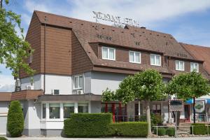 ein Gebäude mit einem braunen Dach in der Unterkunft Hotel Touristik in Neuenburg am Rhein