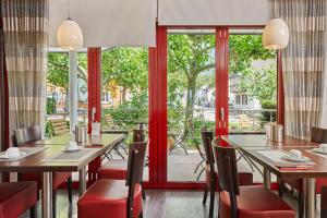 ノイエンビュルク・アム・ラインにあるHotel Touristikのテーブルと椅子、大きな窓のあるレストラン