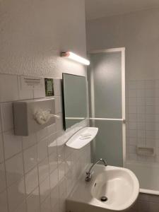 a bathroom with a sink and a mirror at Logis Hotel Restaurant des Voyageurs in Le Malzieu-Ville