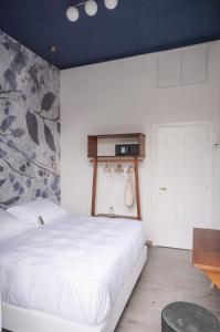 1 dormitorio con cama blanca y techo azul en Il Caruggio Home, en Varazze