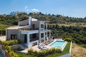 a villa with a swimming pool on a hill at Villa Tina in Maroulás