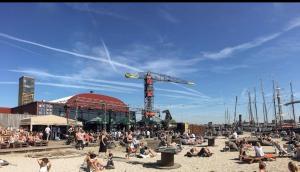 eine Gruppe von Menschen, die auf dem Sand am Strand sitzen in der Unterkunft B&B Twiske Zuid, Amsterdam free parking in Amsterdam