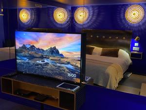 Private Room & Spa avec jacuzzi privatif في ليل: تلفزيون في غرفة بسرير ومقهى