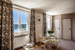 a dining room with a table and chairs and a window at Logis Hôtel Beau Site in Loubaresse