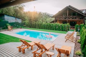 a backyard with a pool with chairs and a pink flamingo at Панська Господа in Vyzhnytsya
