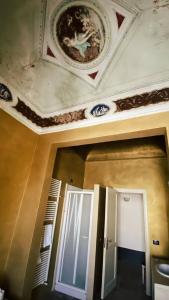 Zimmer mit einer Decke und einer Tür mit einem Gemälde in der Unterkunft Palazzo Gambuzza in Ispica