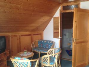 a room with chairs and a table and a tv at Gerti Haus in Bük