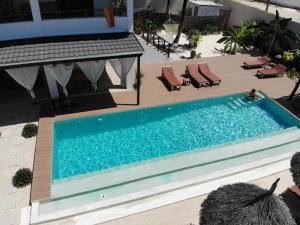 
a swimming pool with a pool table and chairs at Villa Huruma in Paje
